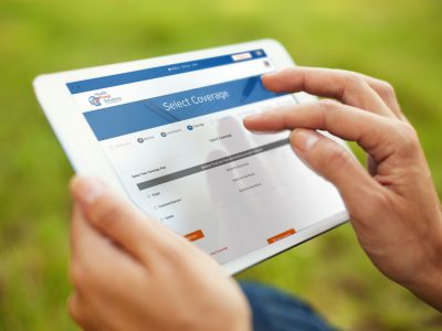 close up of hands touching ipad to select coverage while person is standing on the grass