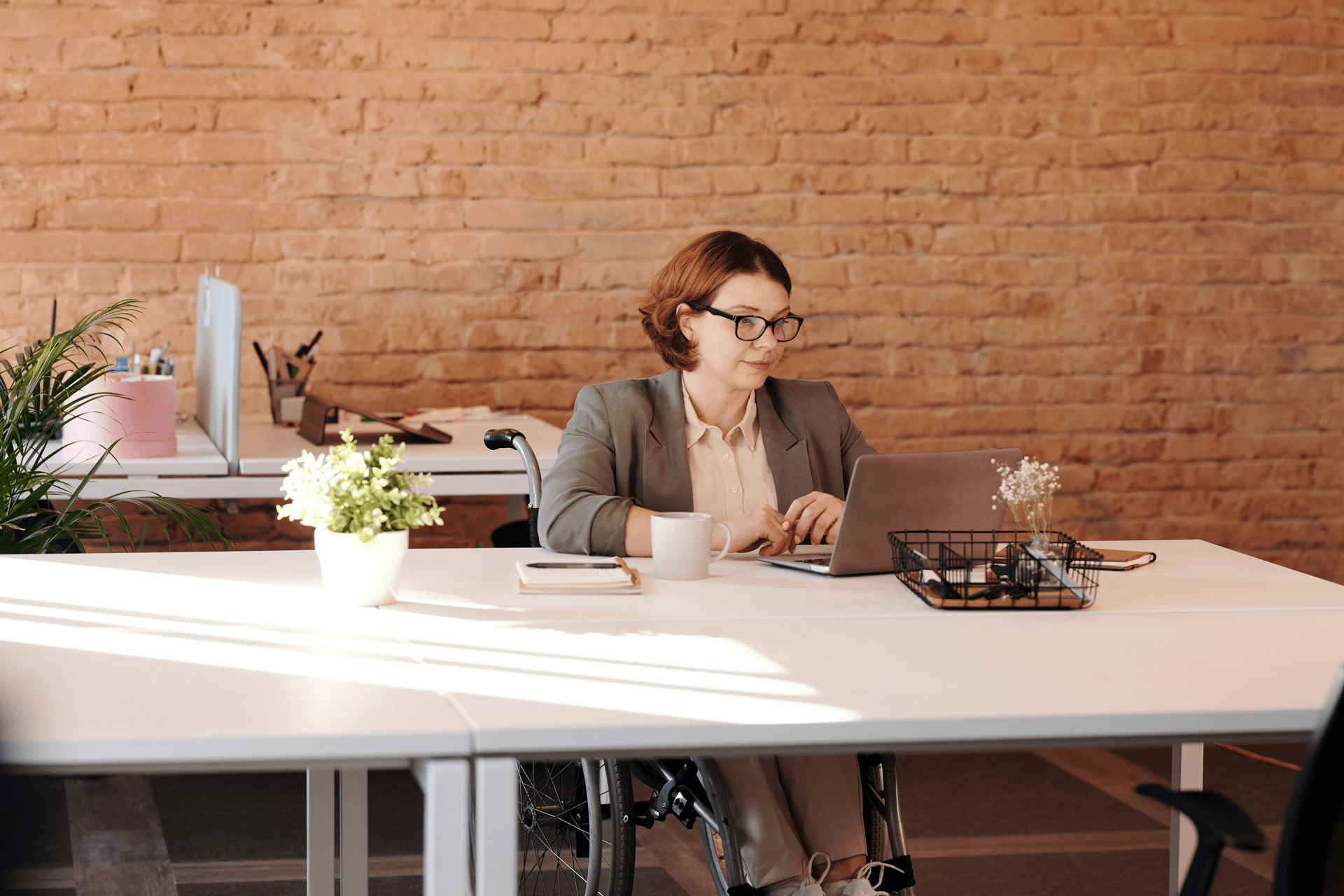 office worker at her desk with a laptop and cup of coffee