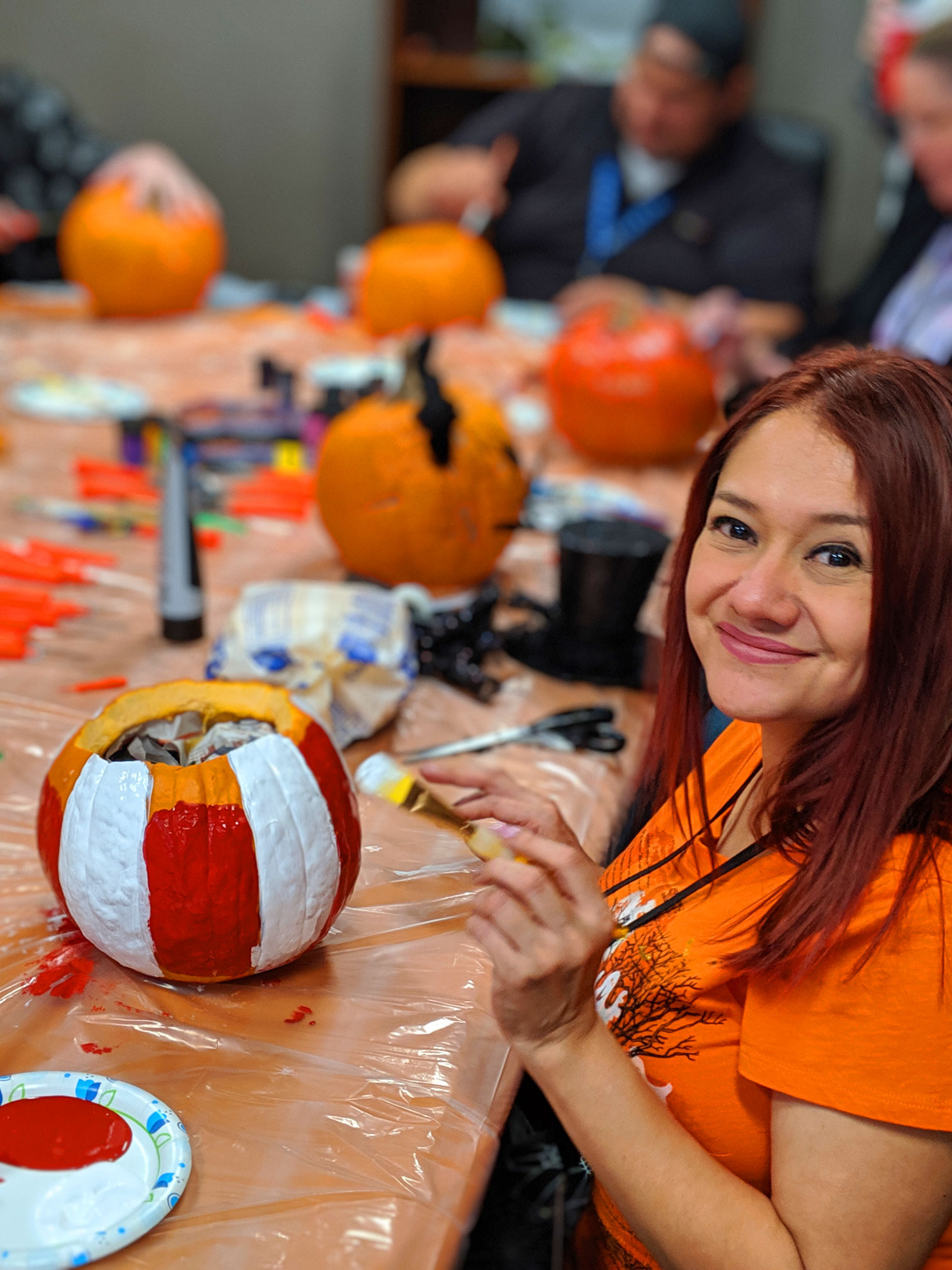 happy employee painting a pumpkin