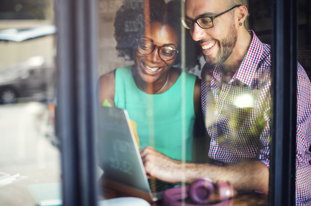 happy couple looking at a laptop