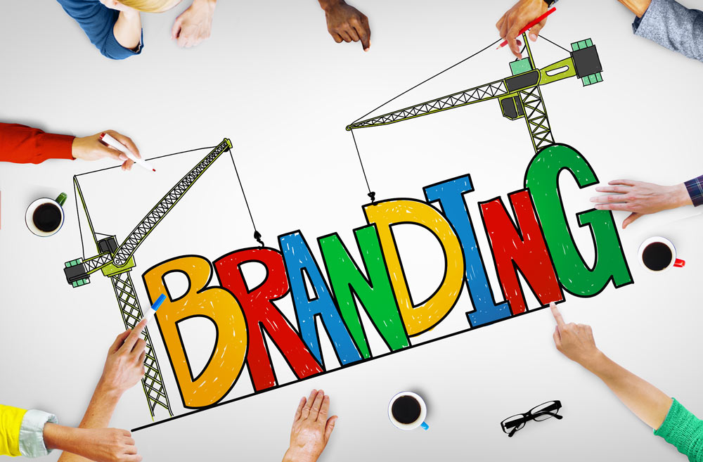 various hands around a drawing board, spelling out the word -branding-