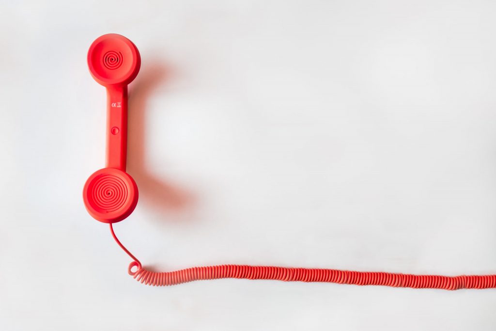 red corded phone with cord trailing off the camera screen