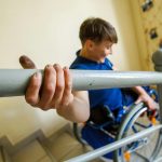 person struggles to descend stairs while in a wheelchair